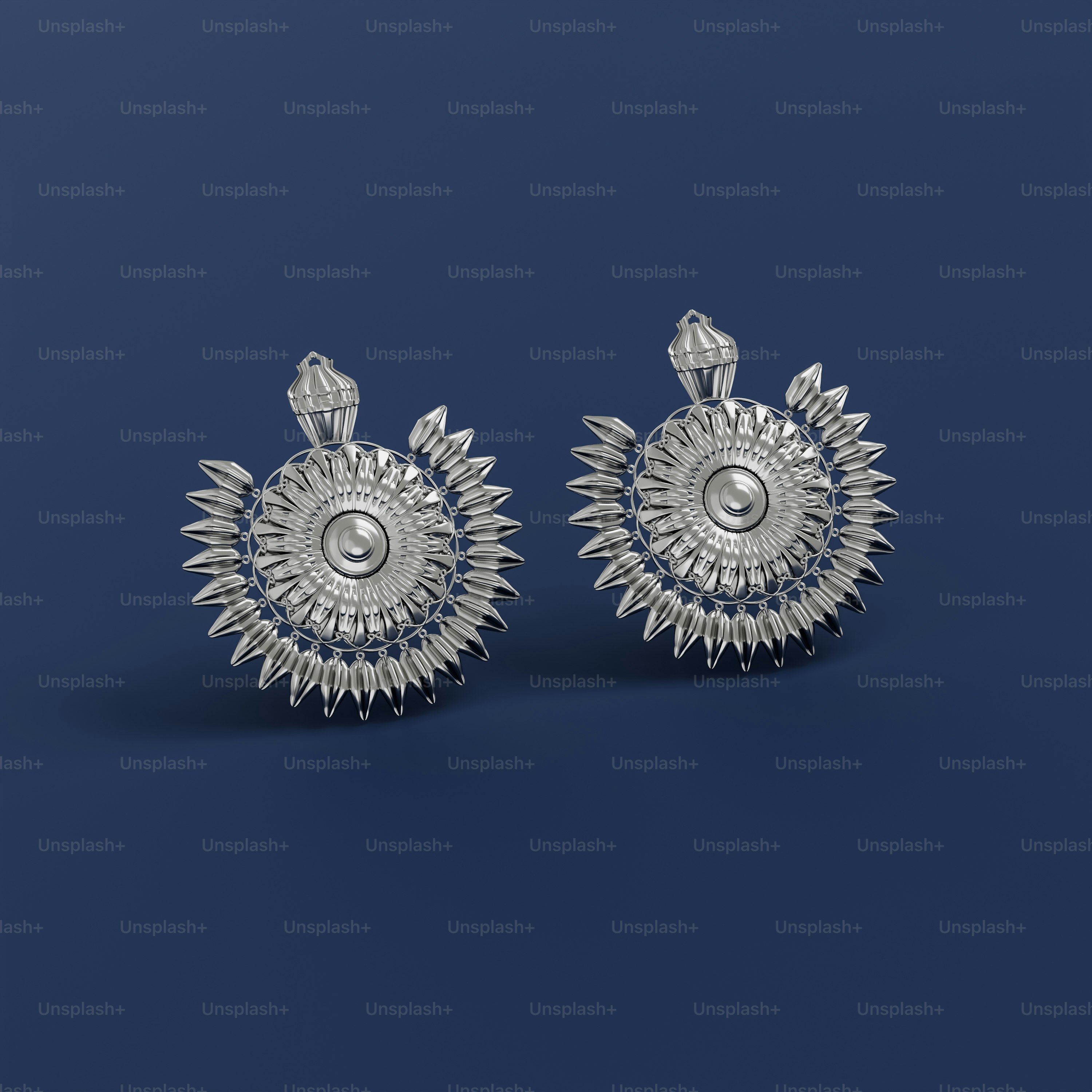 a pair of silver earrings on a blue background