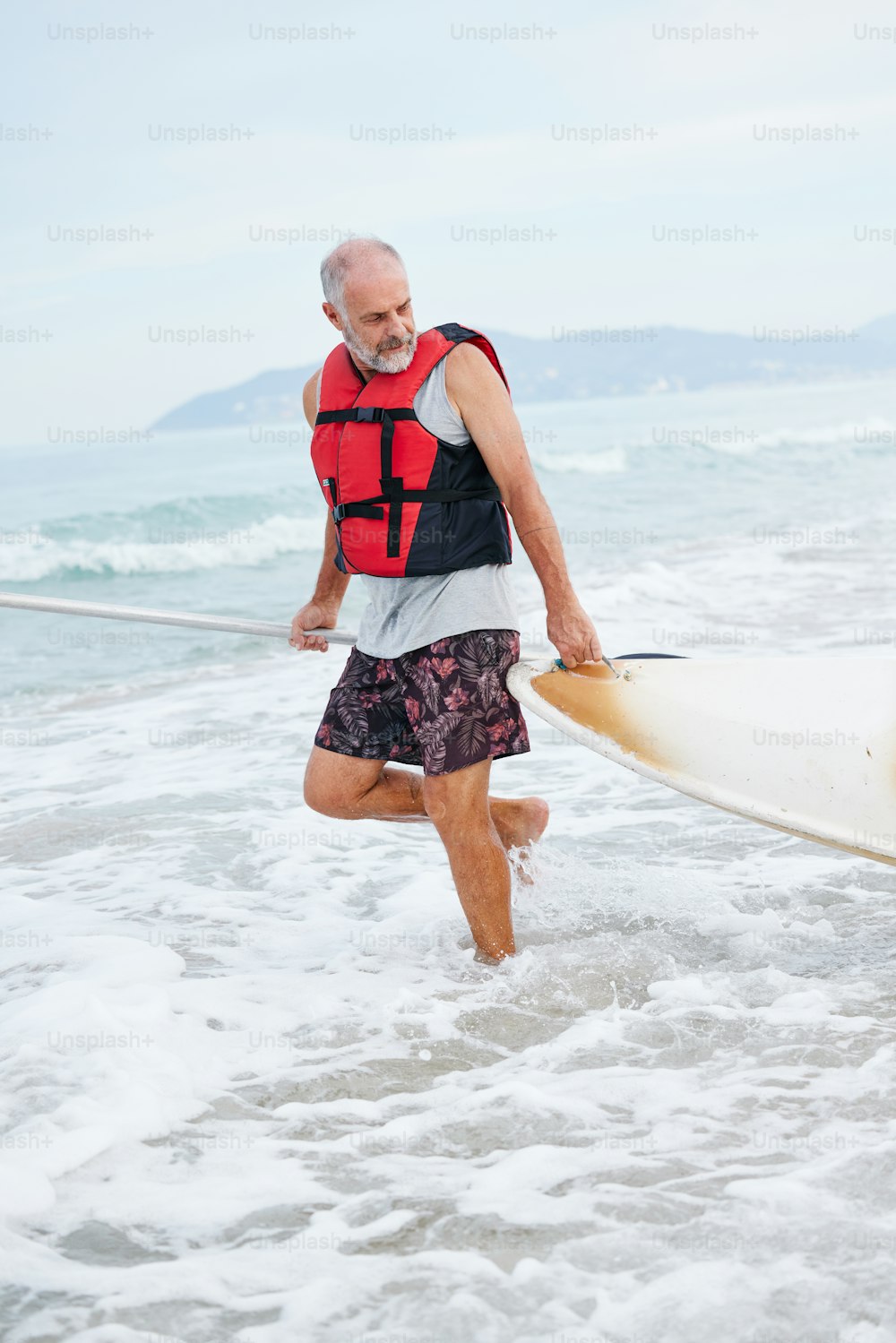 Un hombre caminando hacia el océano con una tabla de surf