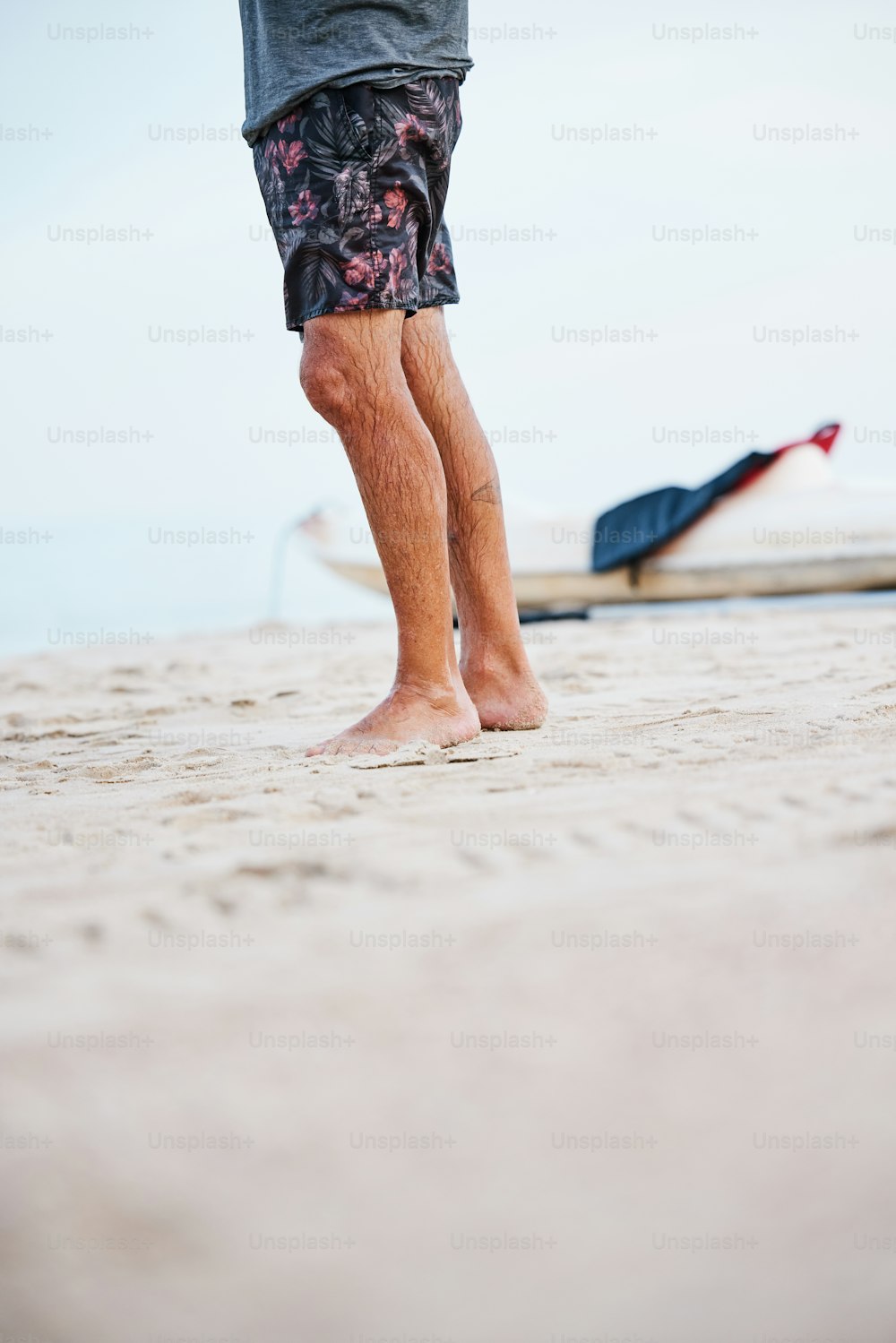 a person standing on a beach with their feet in the sand