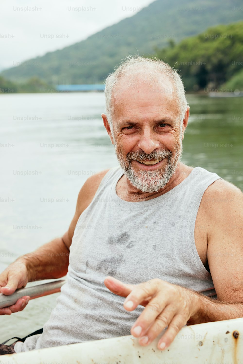 a man sitting in a boat pointing at the camera