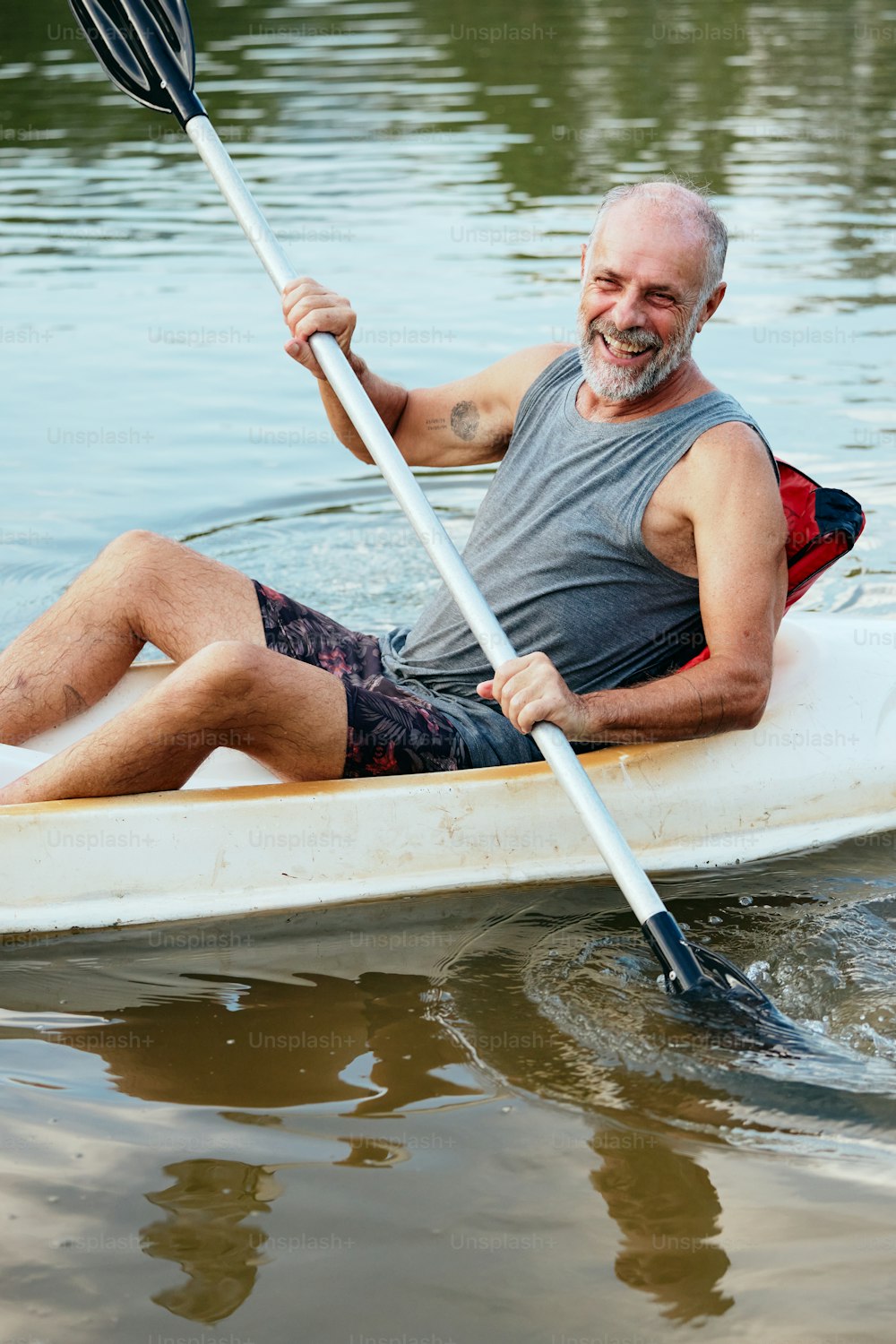 男が水上でカヌーを漕いでいる