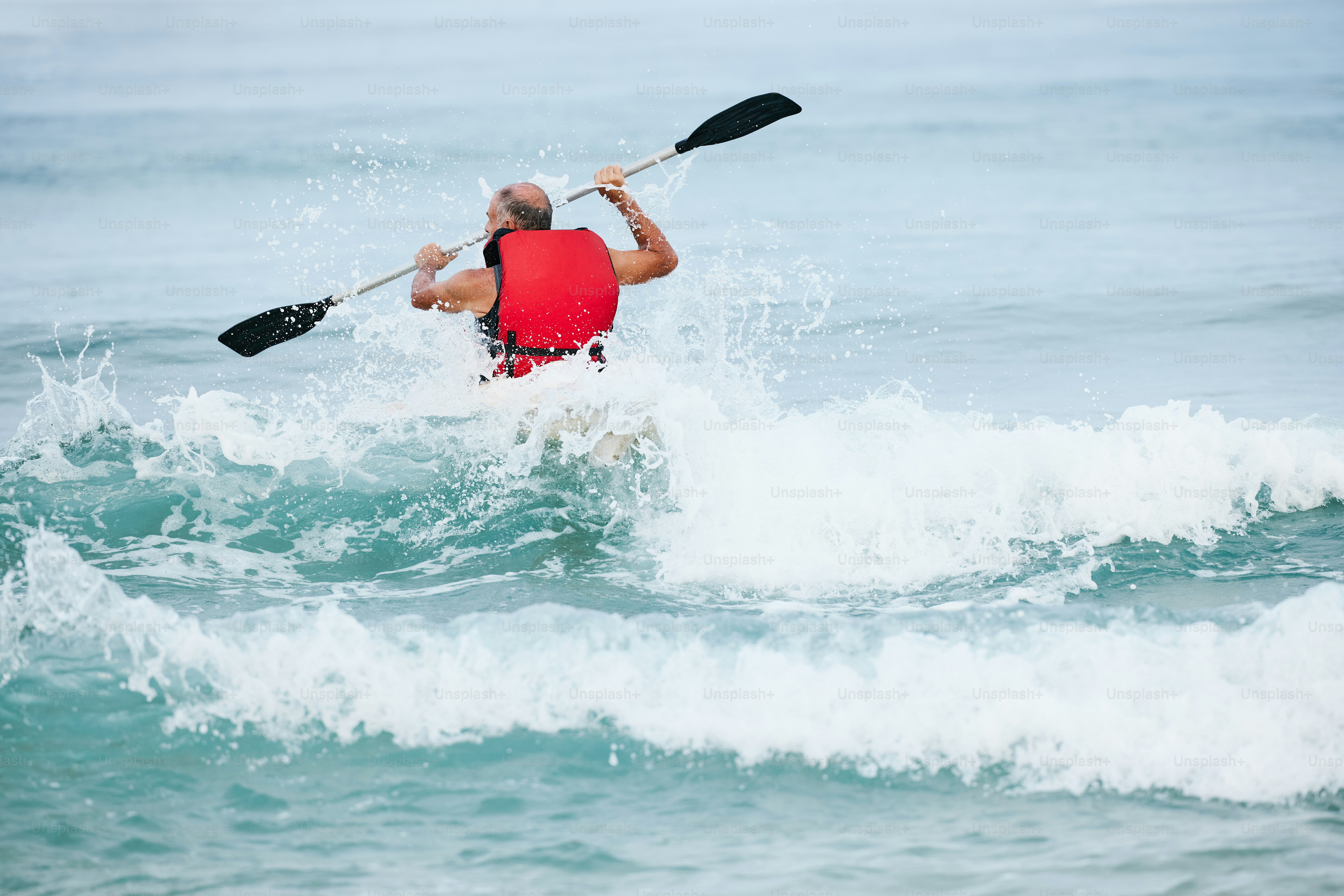 Ein Mann, der auf einem Paddelboot im Ozean reitet