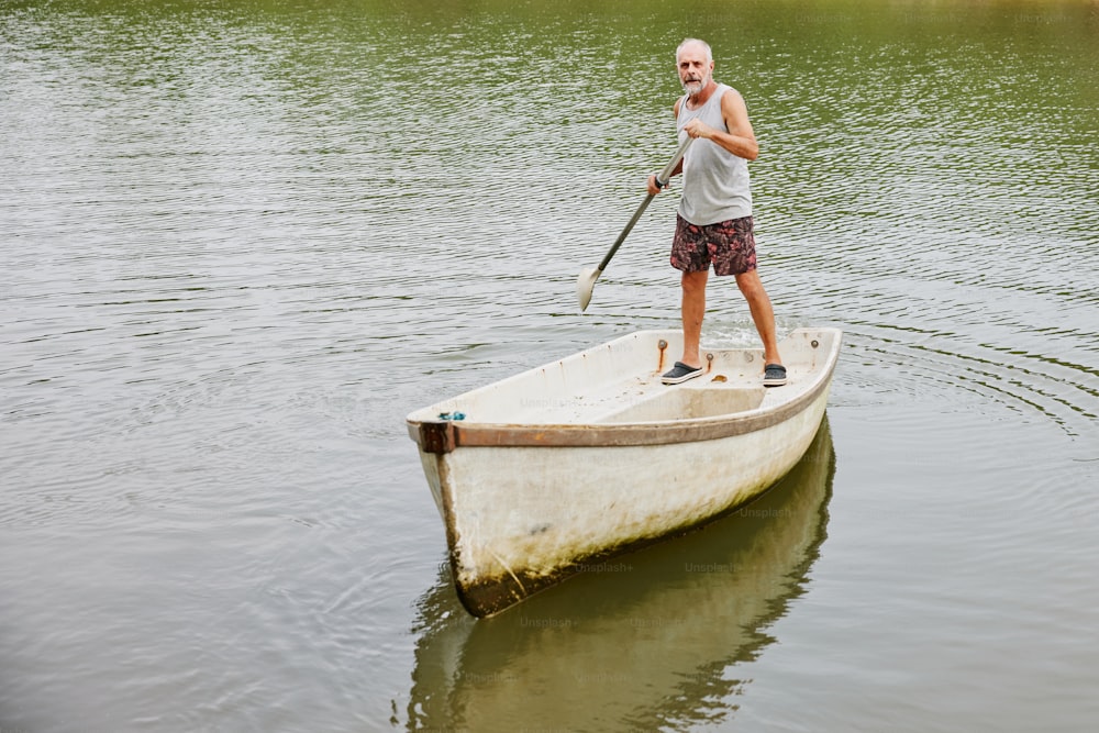 男が湖でボートを漕ぐ