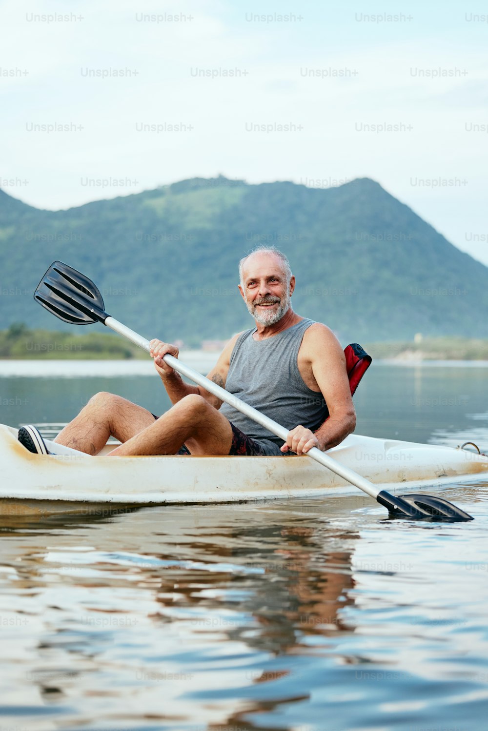Ein Mann sitzt in einem Kajak auf einem See