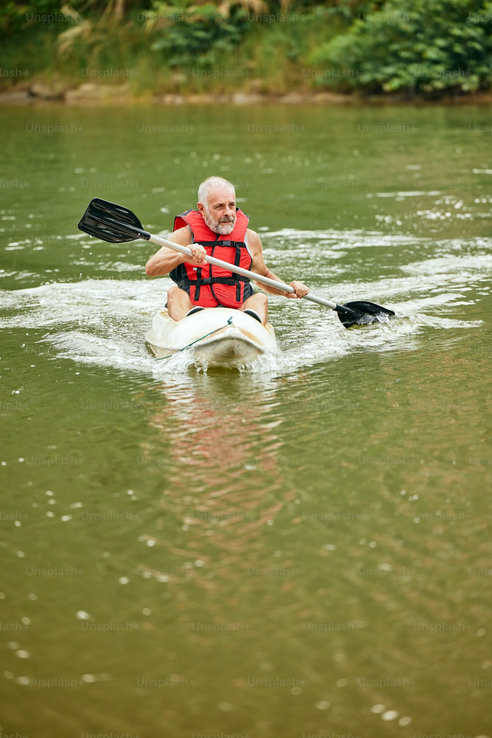 a man riding a kayak on top of a river