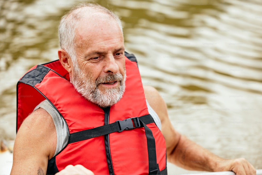 a man in a life jacket paddling a boat