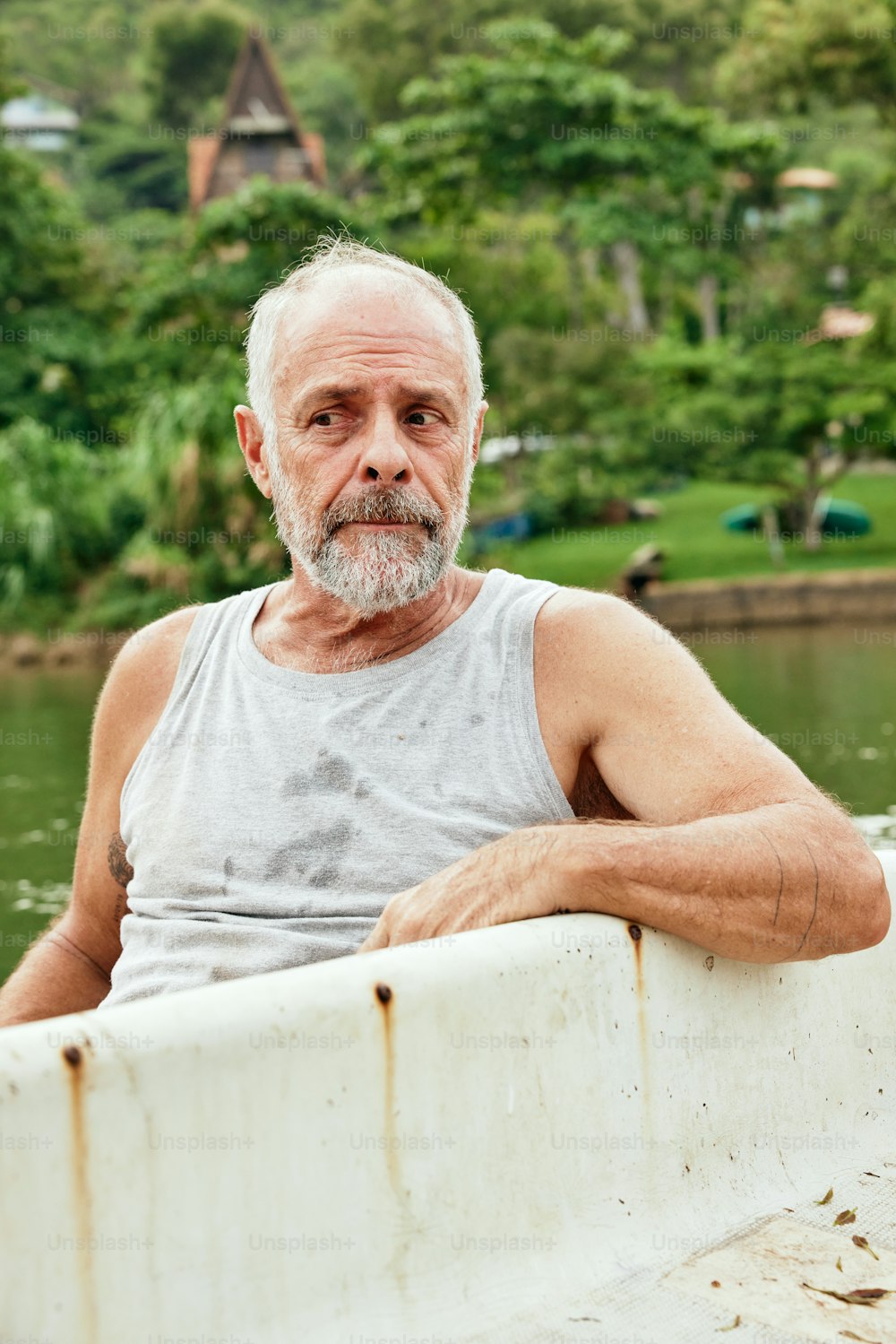 Un uomo anziano appoggiato sul bordo di una barca