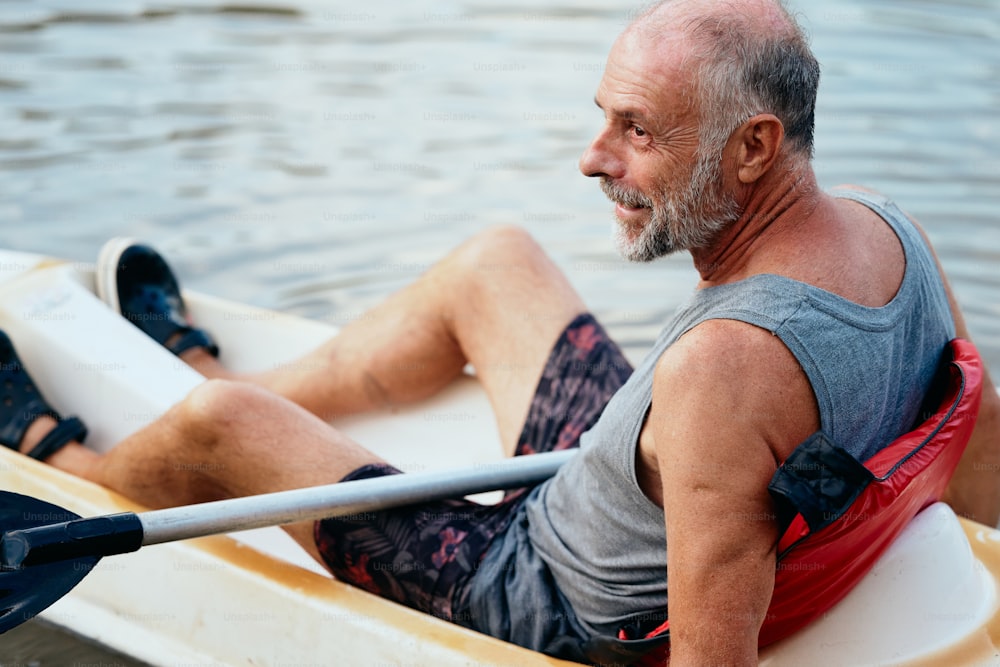 um homem sentado em um barco em um corpo de água
