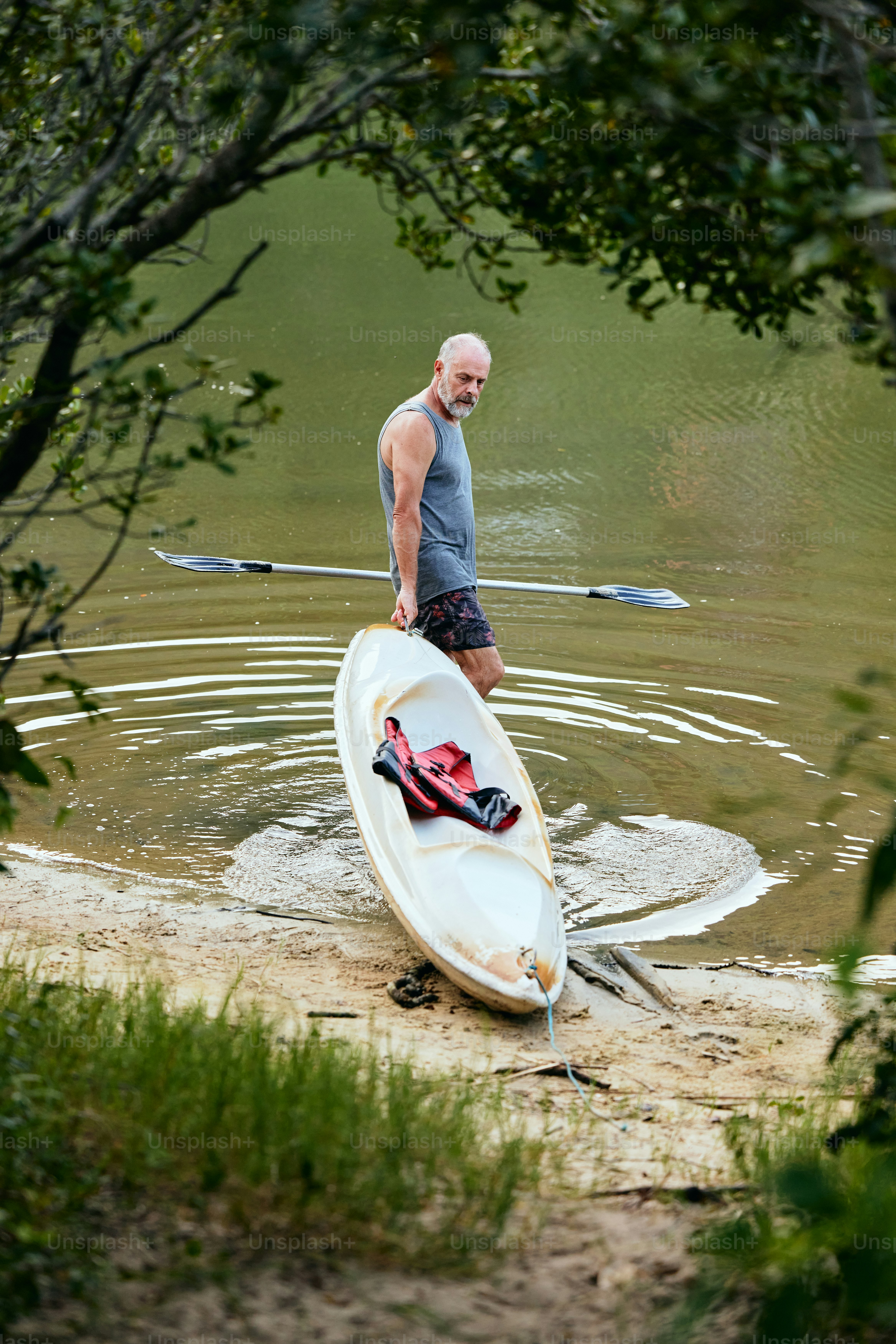 A man standing in the water with a surfboard photo – Boat Image on Unsplash