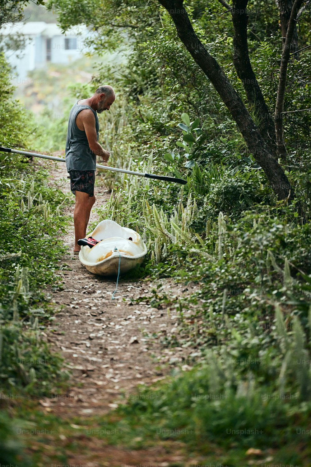 a man standing next to a boat on a dirt road