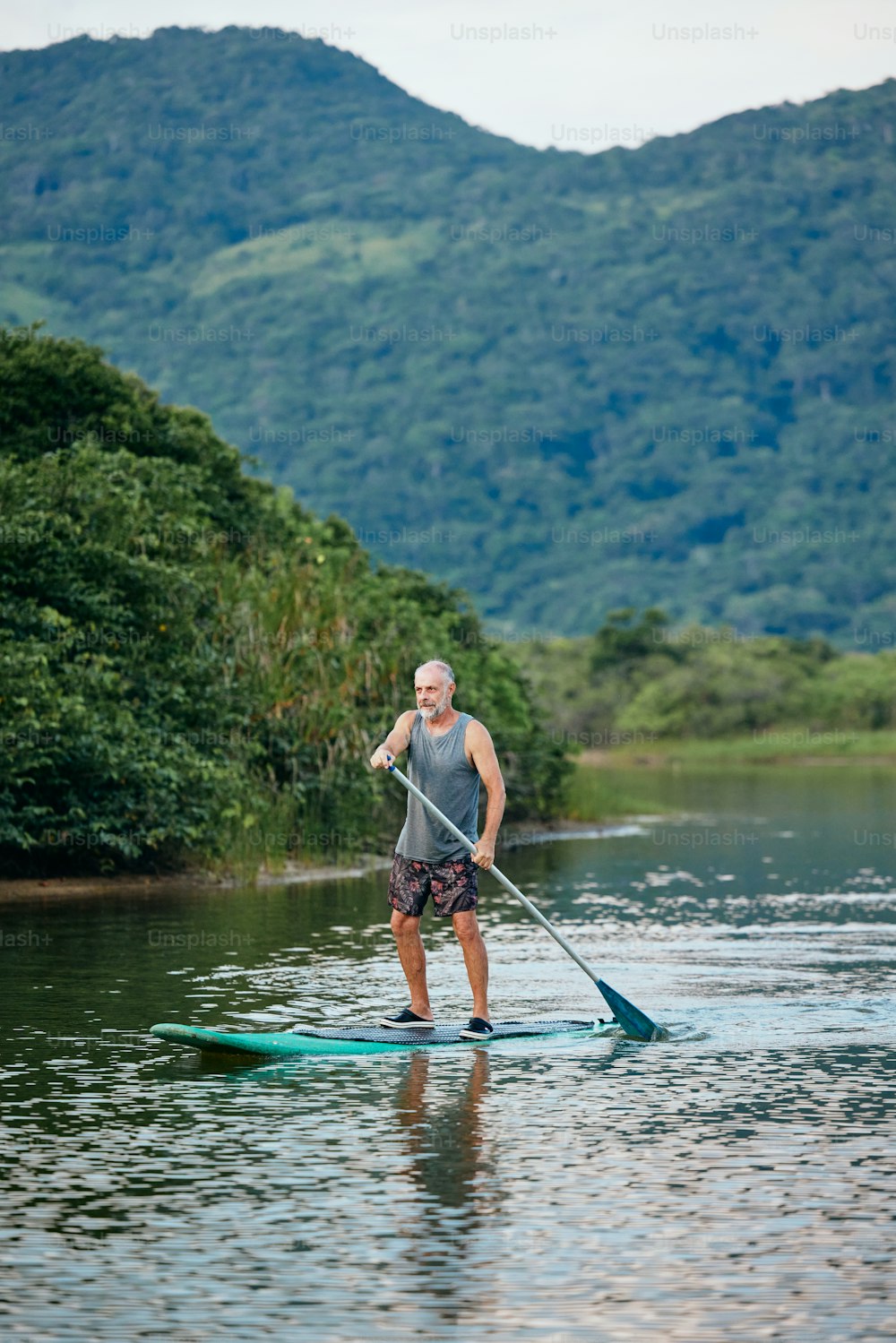 a man riding a paddle board on top of a lake