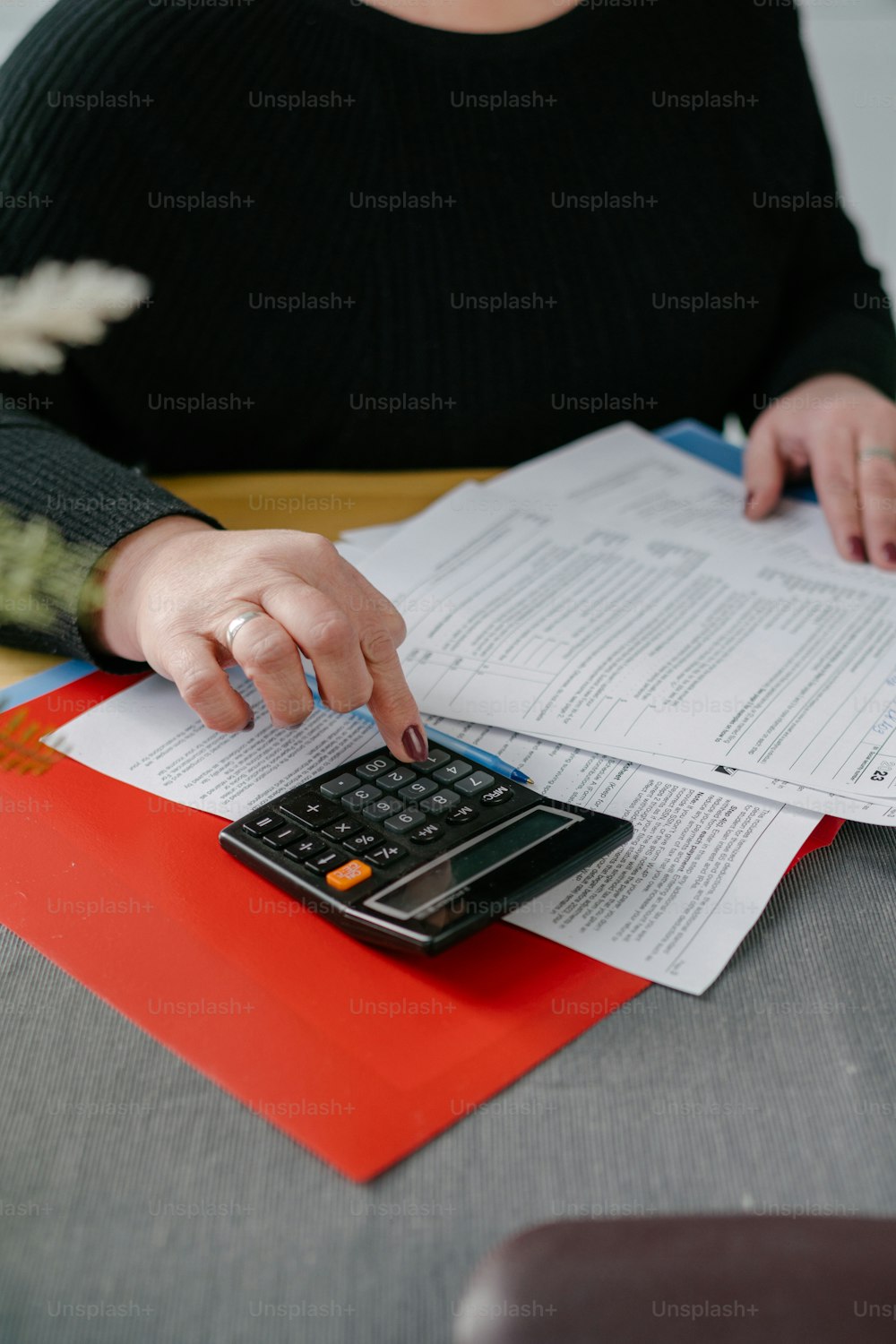 a woman using a calculator on top of a piece of paper