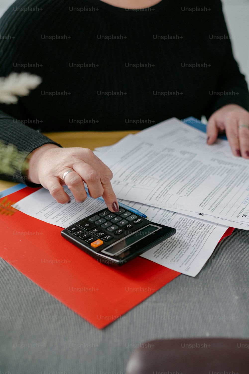 a woman using a calculator on top of a piece of paper