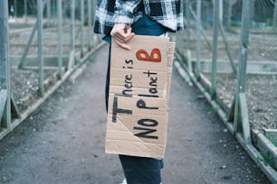 a person standing on a bridge holding a sign