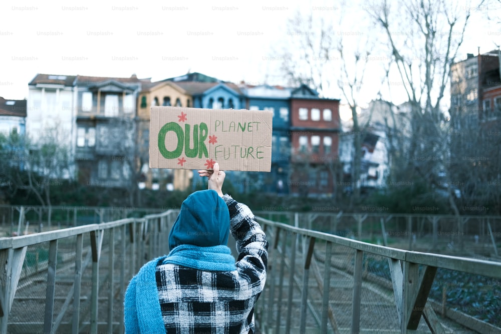 Una persona sosteniendo un cartel que dice que nuestro planeta es futuro