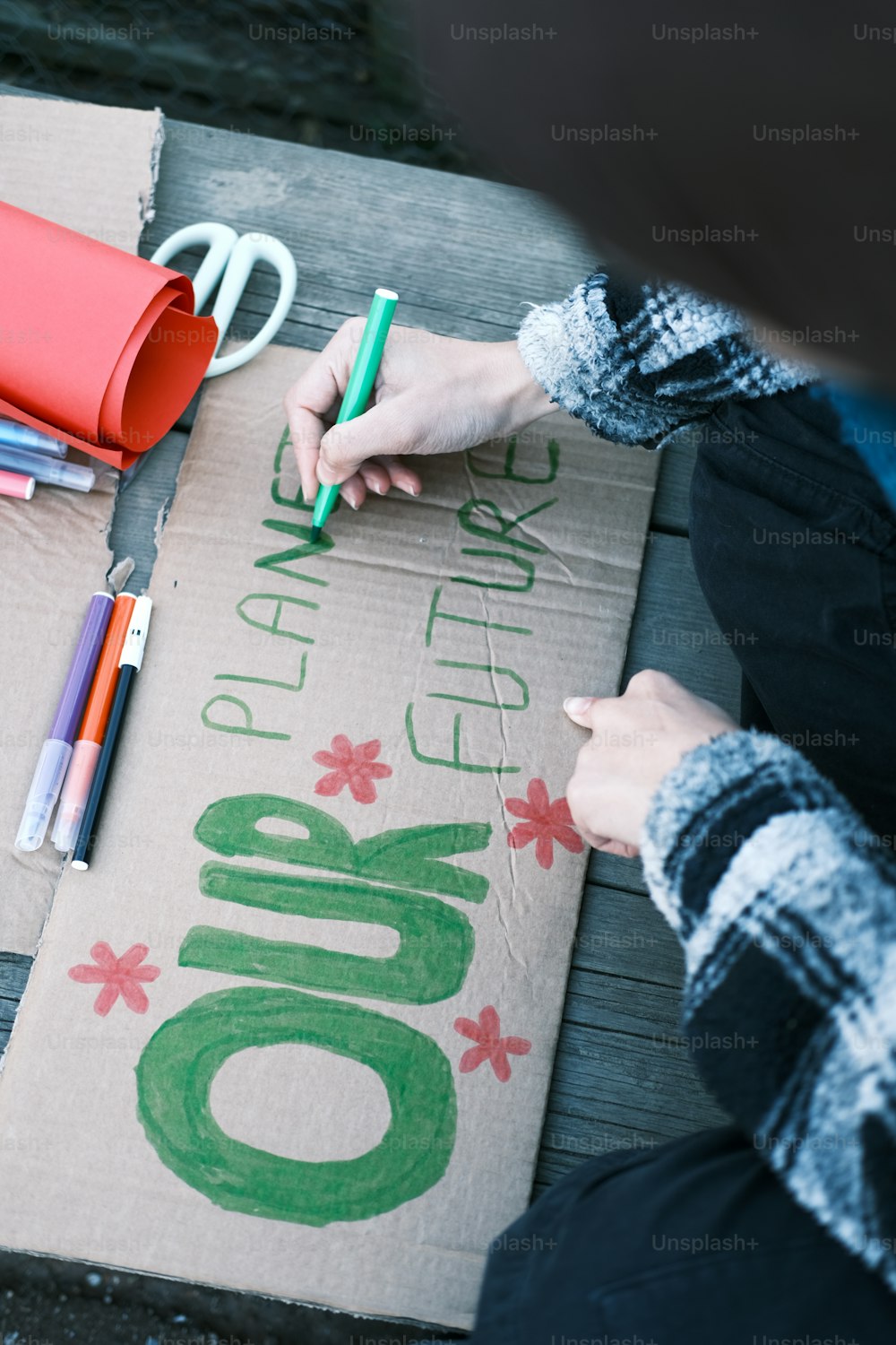 a person with a pair of scissors on a piece of cardboard