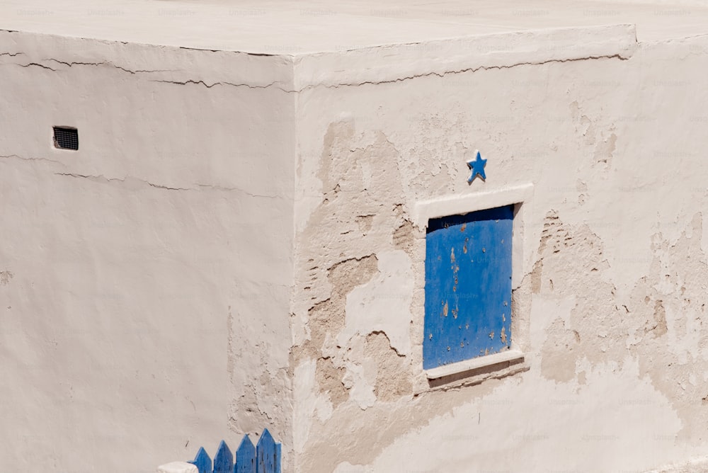 ein weißes Gebäude mit blauer Tür und Fenster