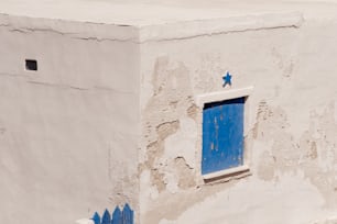 a white building with a blue door and window