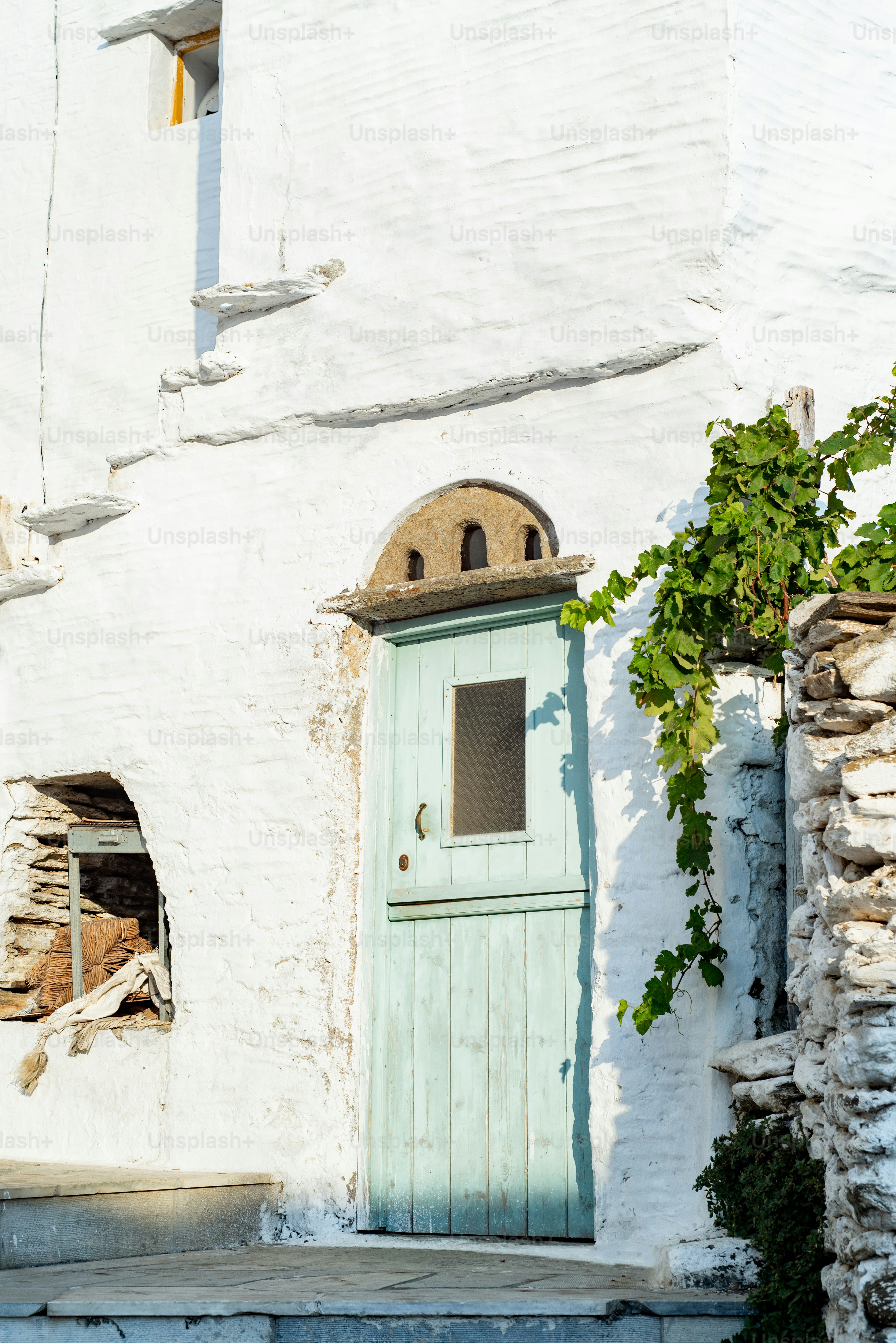 a white building with a green door and window