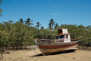 un barco sentado en la cima de una playa de arena