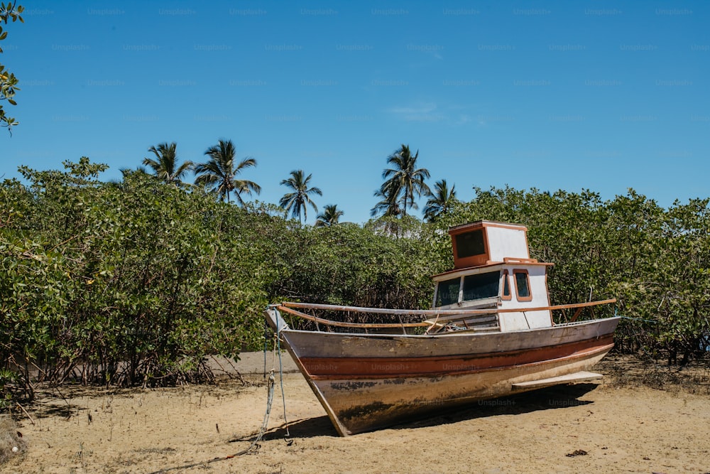 a boat sitting on top of a sandy beach