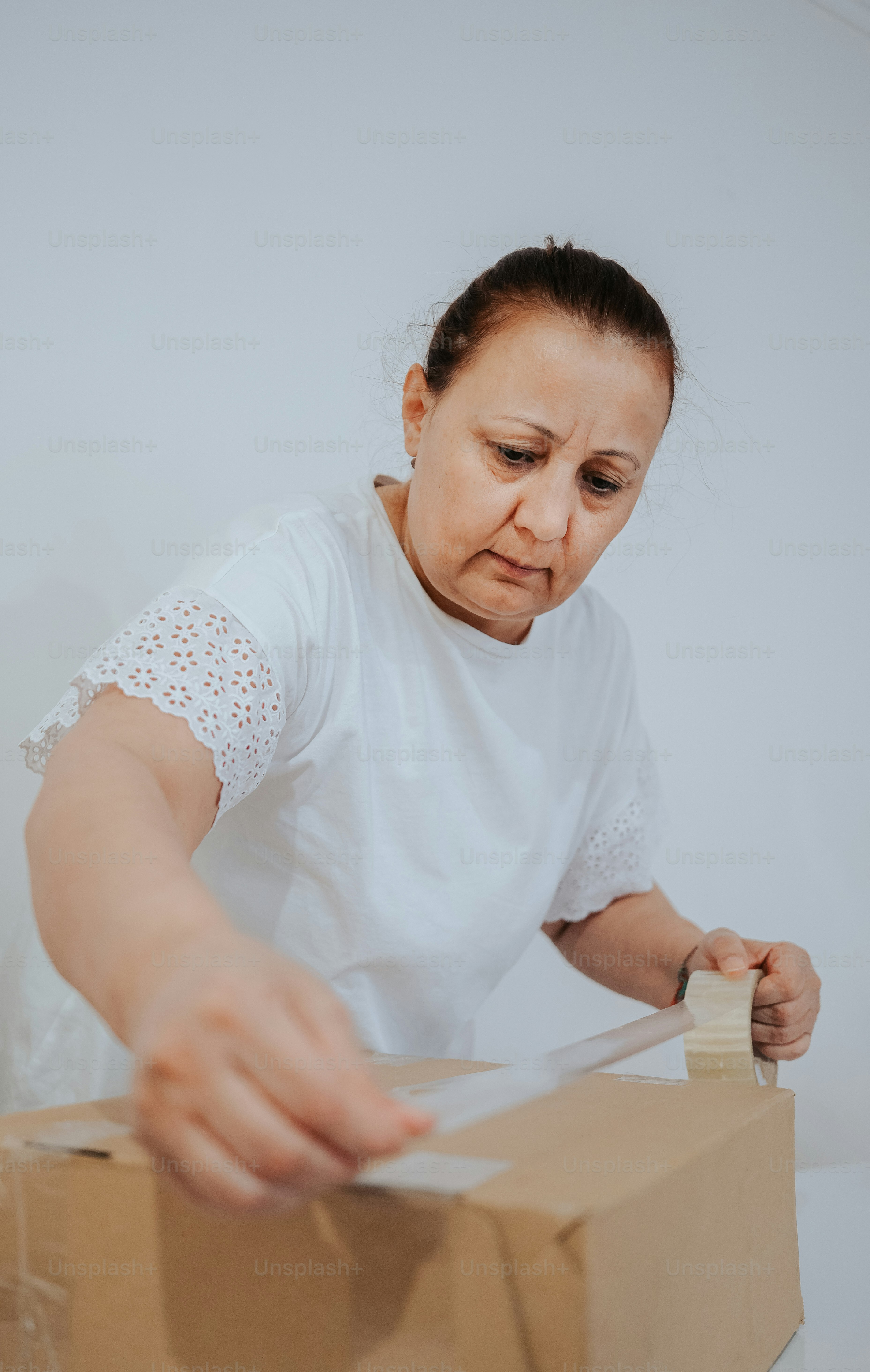 a woman putting a piece of cardboard into a box