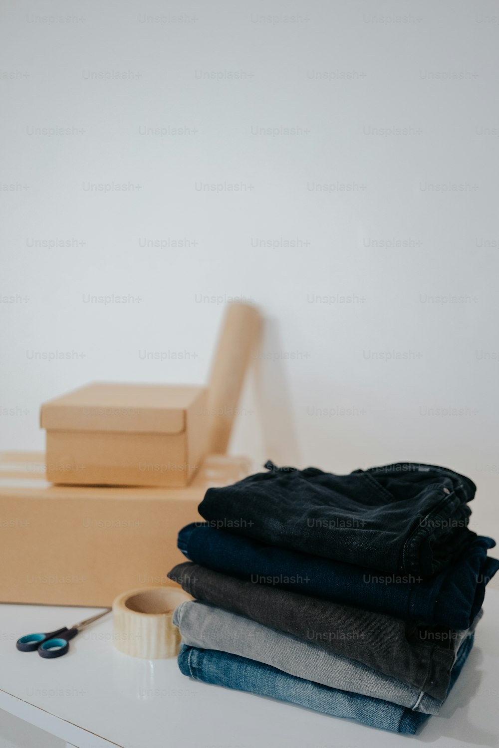 uma pilha de jeans sentados em cima de uma mesa branca