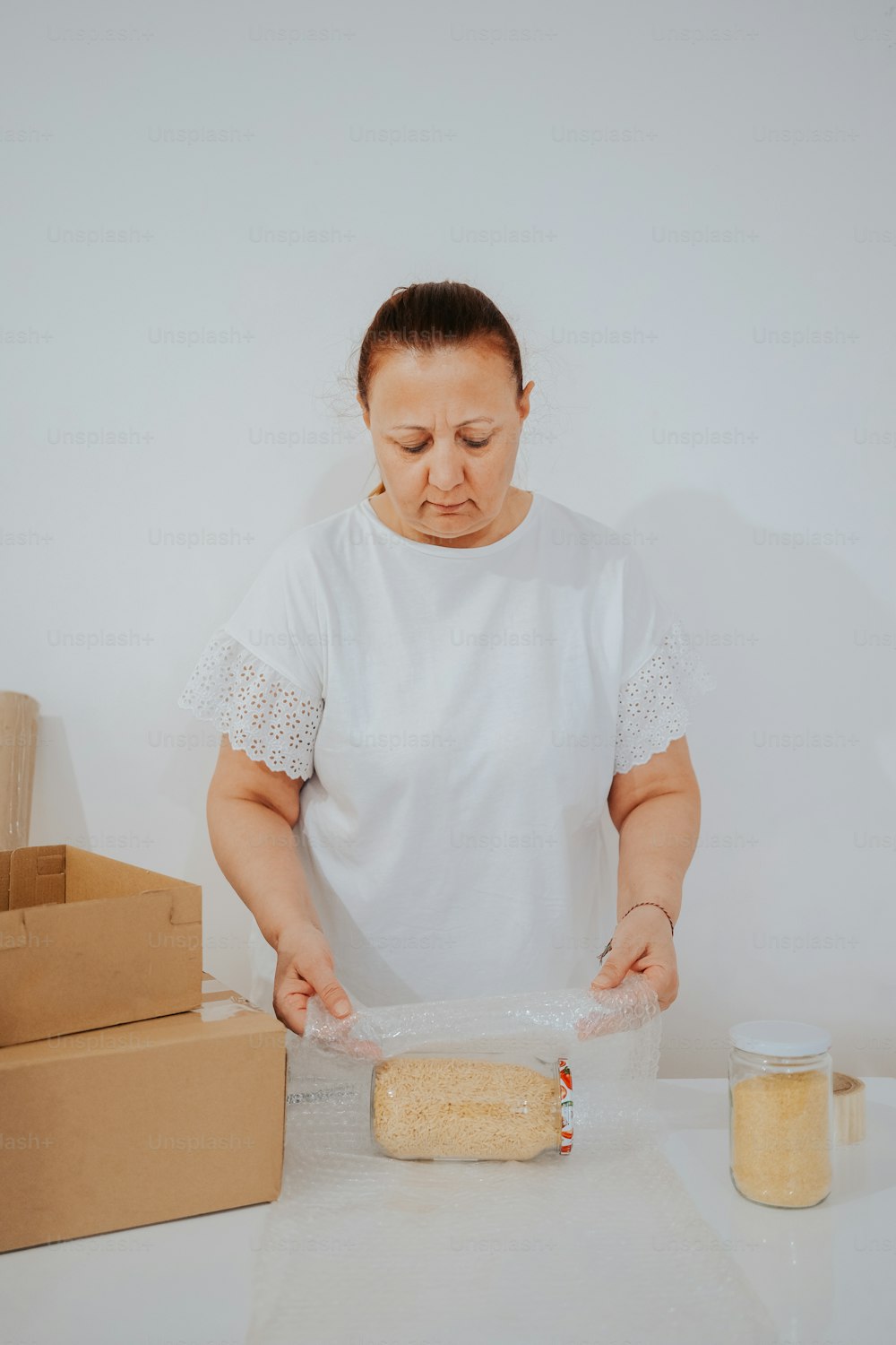 a woman in a white shirt is making a cake