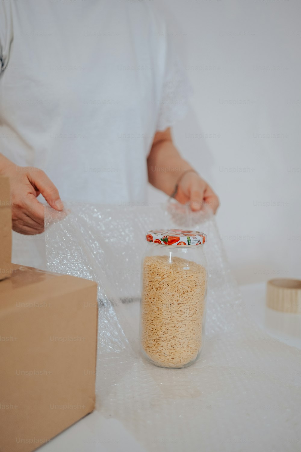 a person holding a plastic bag over a jar of food