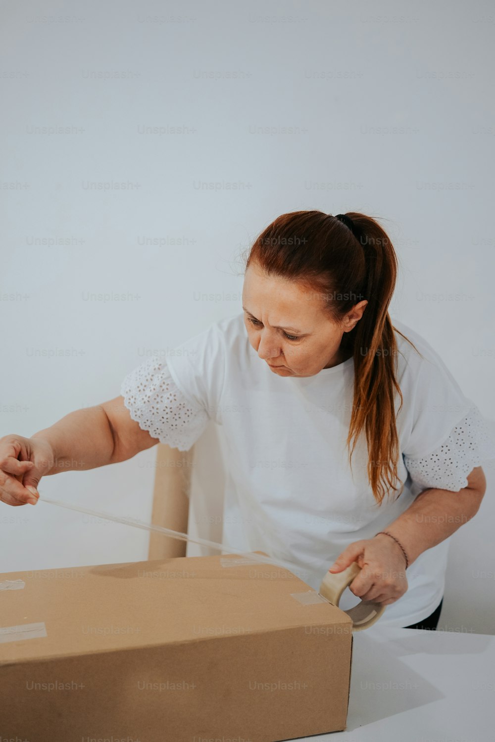 a woman opening a box with a string