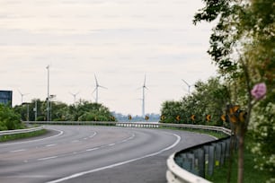 Una strada tortuosa con turbine eoliche sullo sfondo