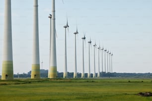 a row of wind turbines in a green field