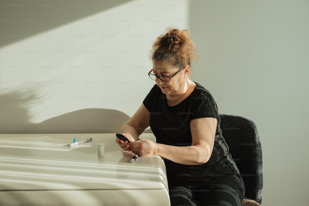 une femme assise à un bureau utilisant un téléphone cellulaire