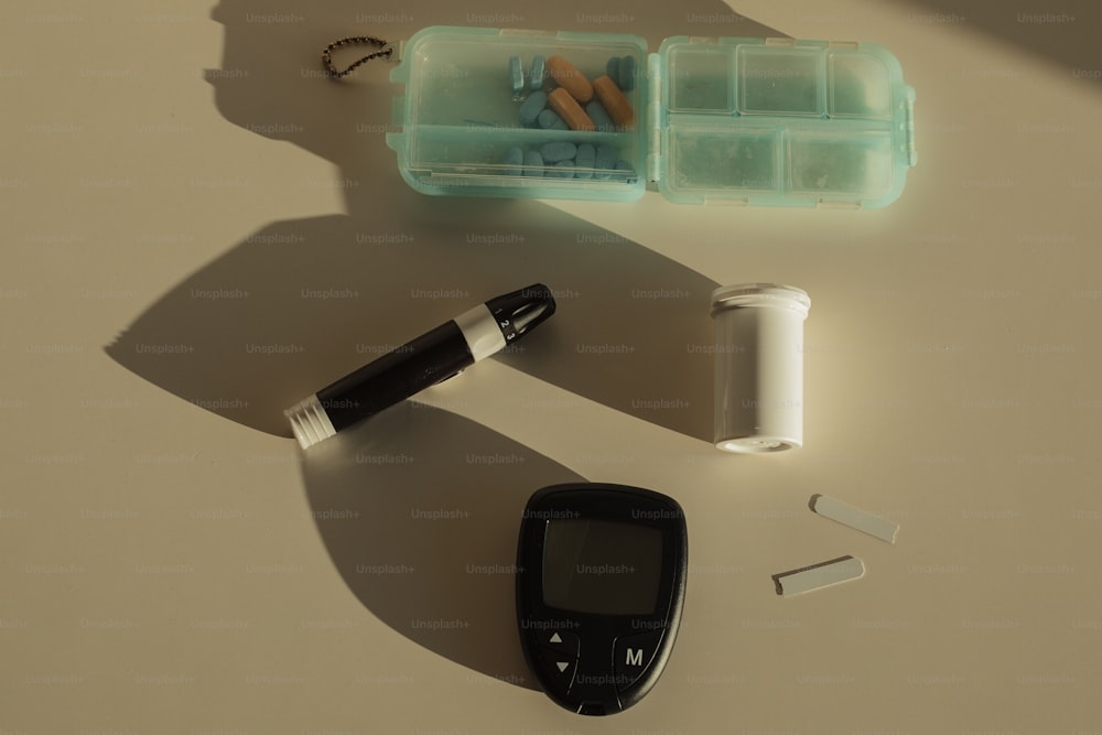 un teléfono celular, un bolígrafo y un soporte de pastillas sobre una mesa