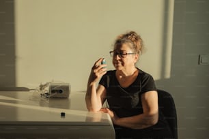 a woman sitting at a desk taking a picture of herself