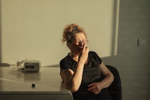 a woman sitting at a desk talking on a cell phone