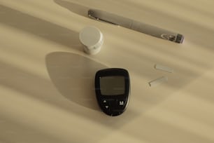 un telefono cellulare seduto sopra un tavolo accanto a una penna
