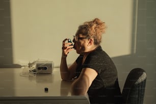 a woman sitting at a desk taking a picture of herself
