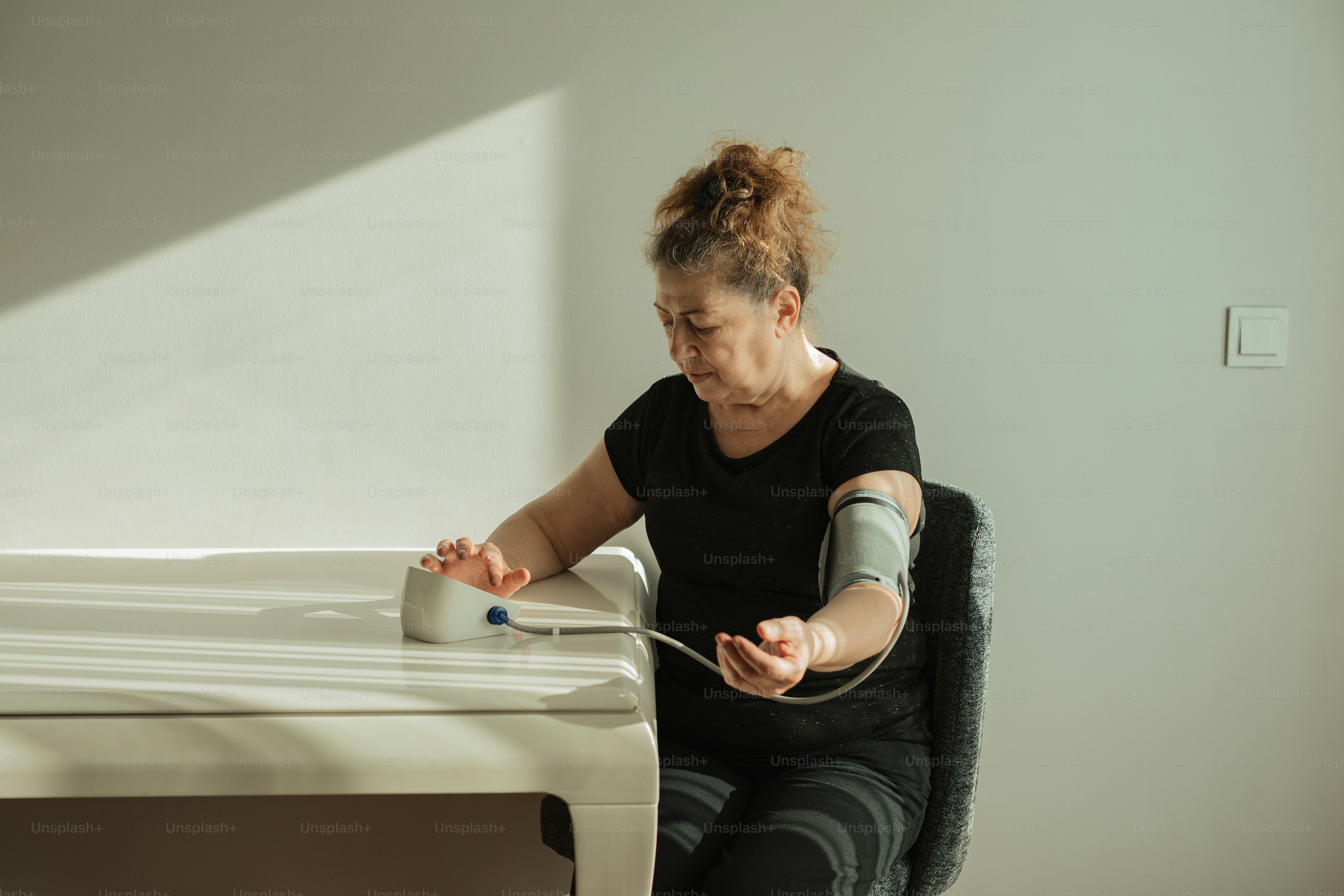 Une femme avec un plâtre sur le bras assise à une table