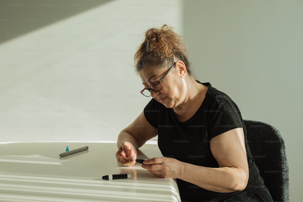 une femme assise à un bureau avec un stylo à la main