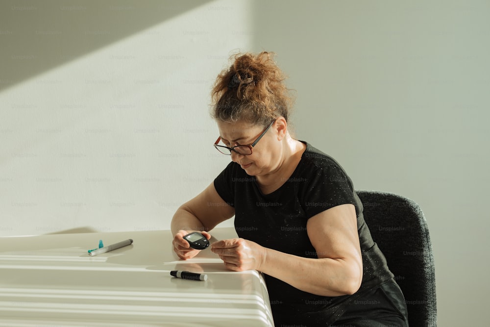 Una donna seduta a una scrivania con un telefono cellulare