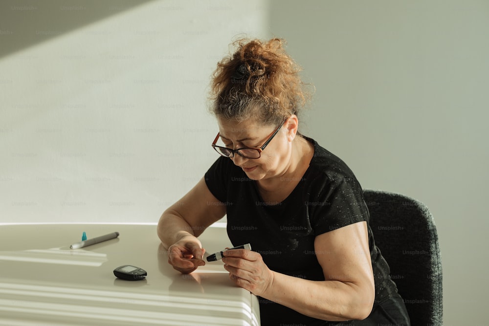 a woman sitting at a table with a cell phone