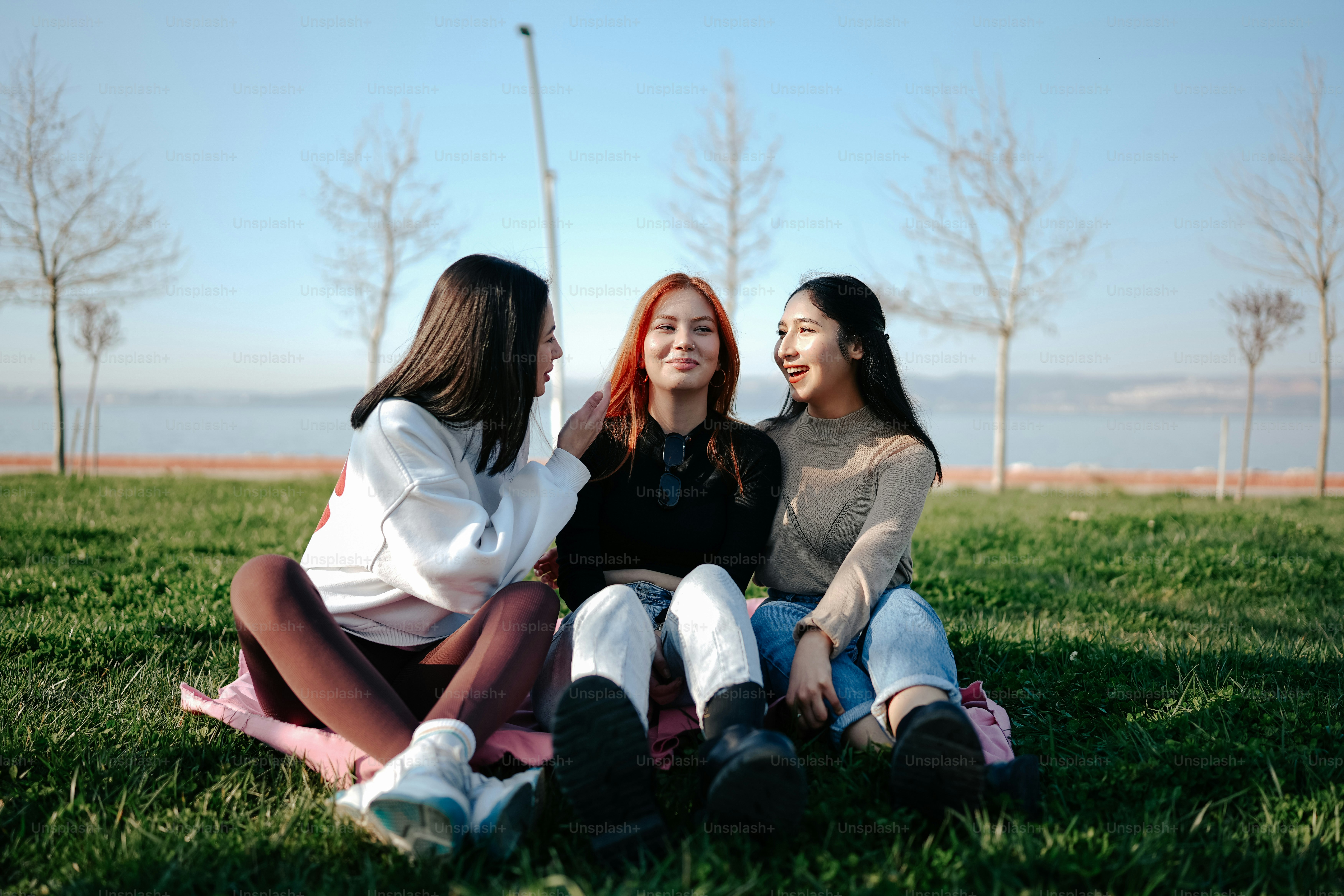 Tres mujeres sentadas en la hierba hablando entre sí