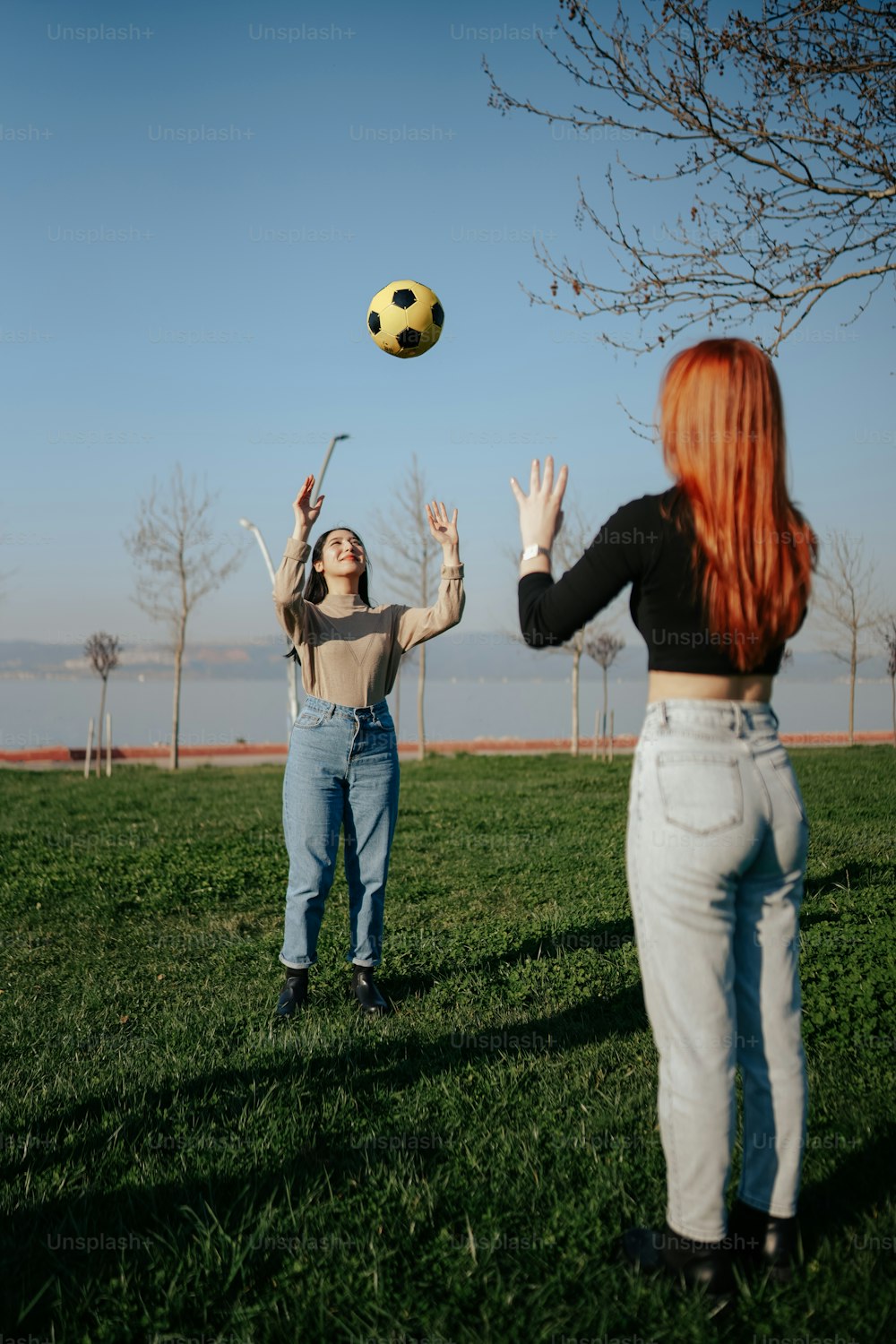 Zwei Frauen, die mit einem Fußball auf einem Feld spielen