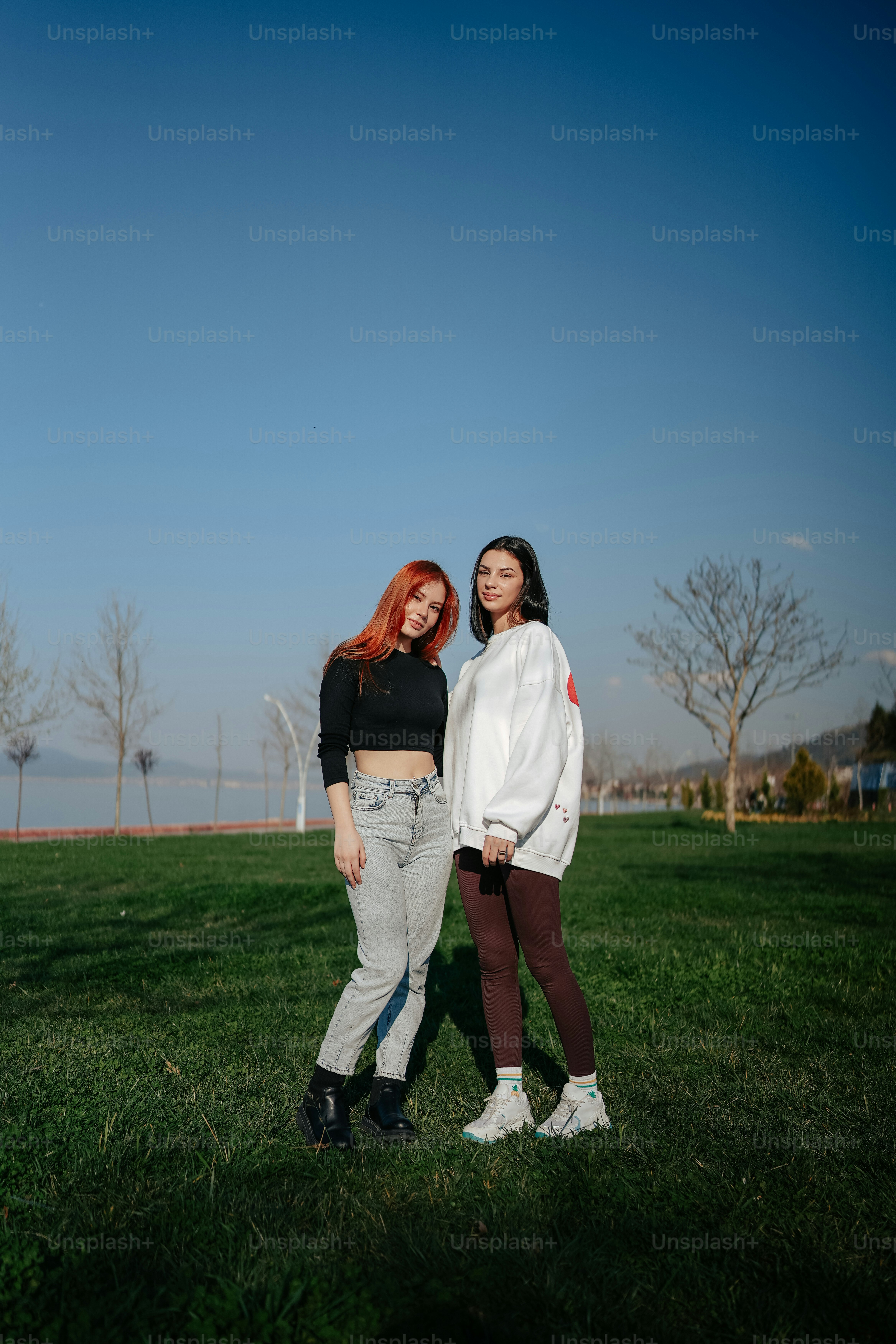 two women standing next to each other in a field