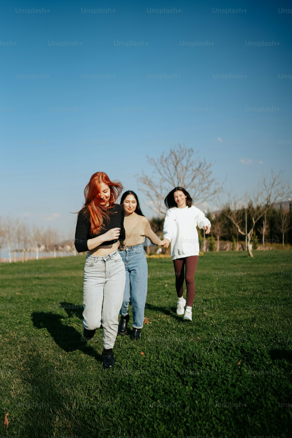 a group of women standing on top of a lush green field