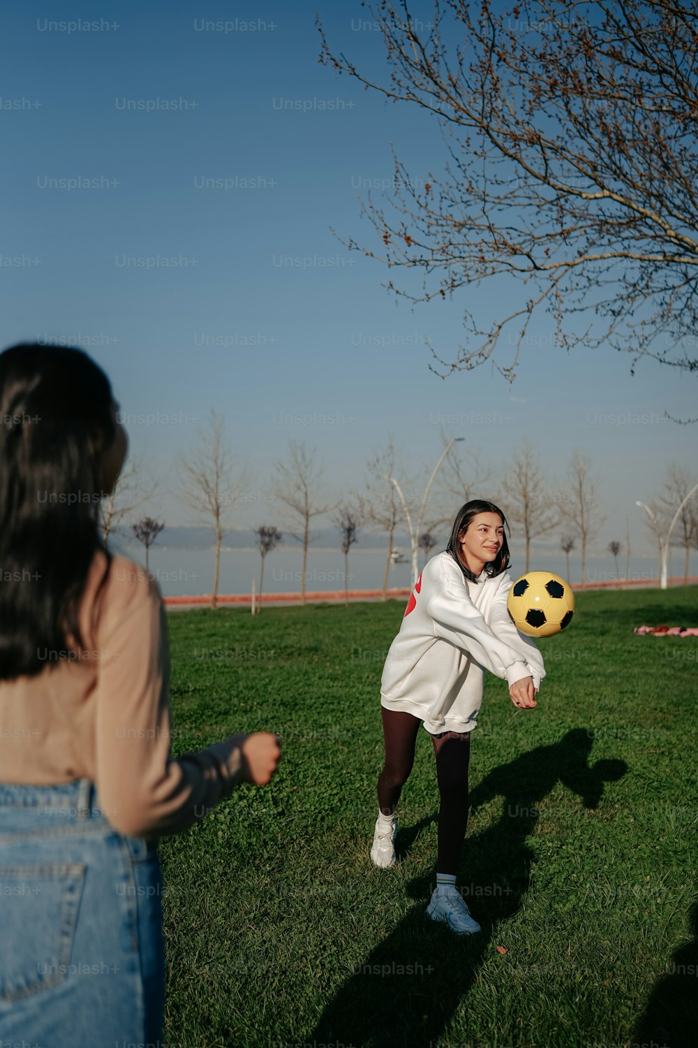 a woman holding a soccer ball in a field