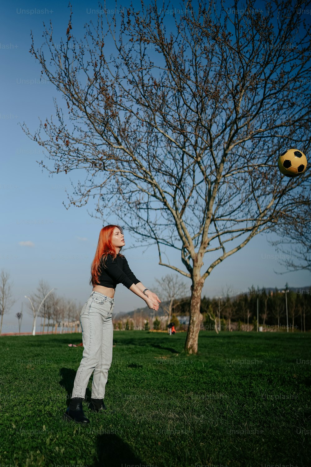 a woman is throwing a soccer ball in a field