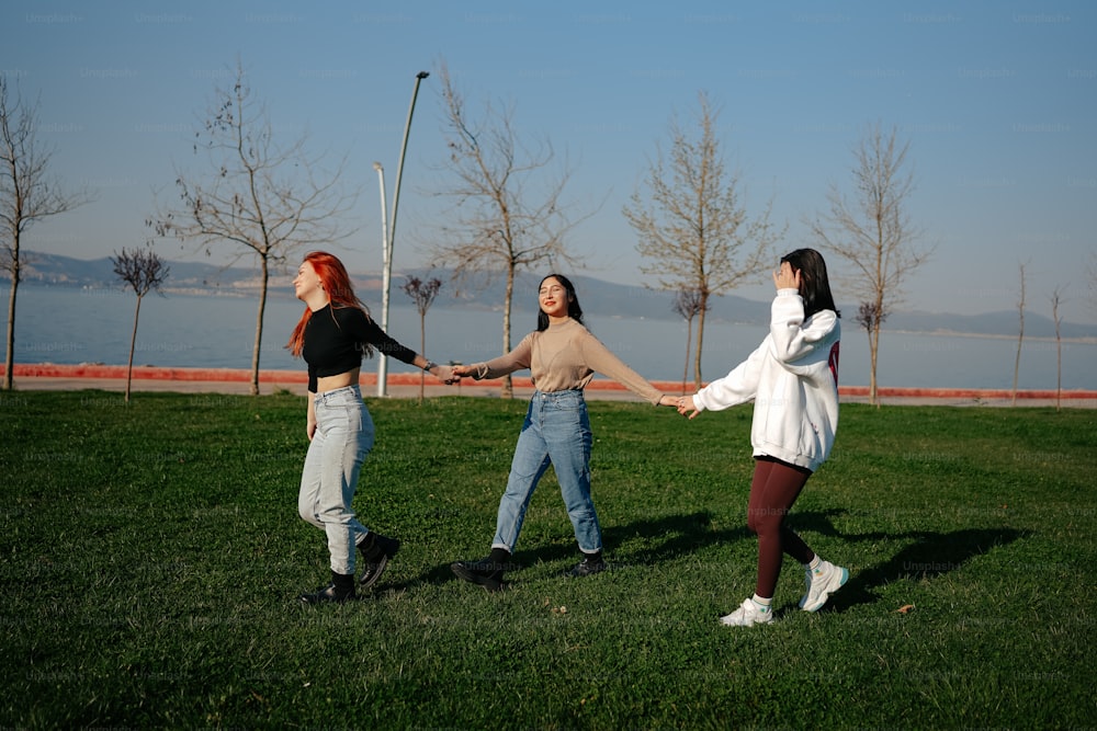 a group of young women holding hands in a park