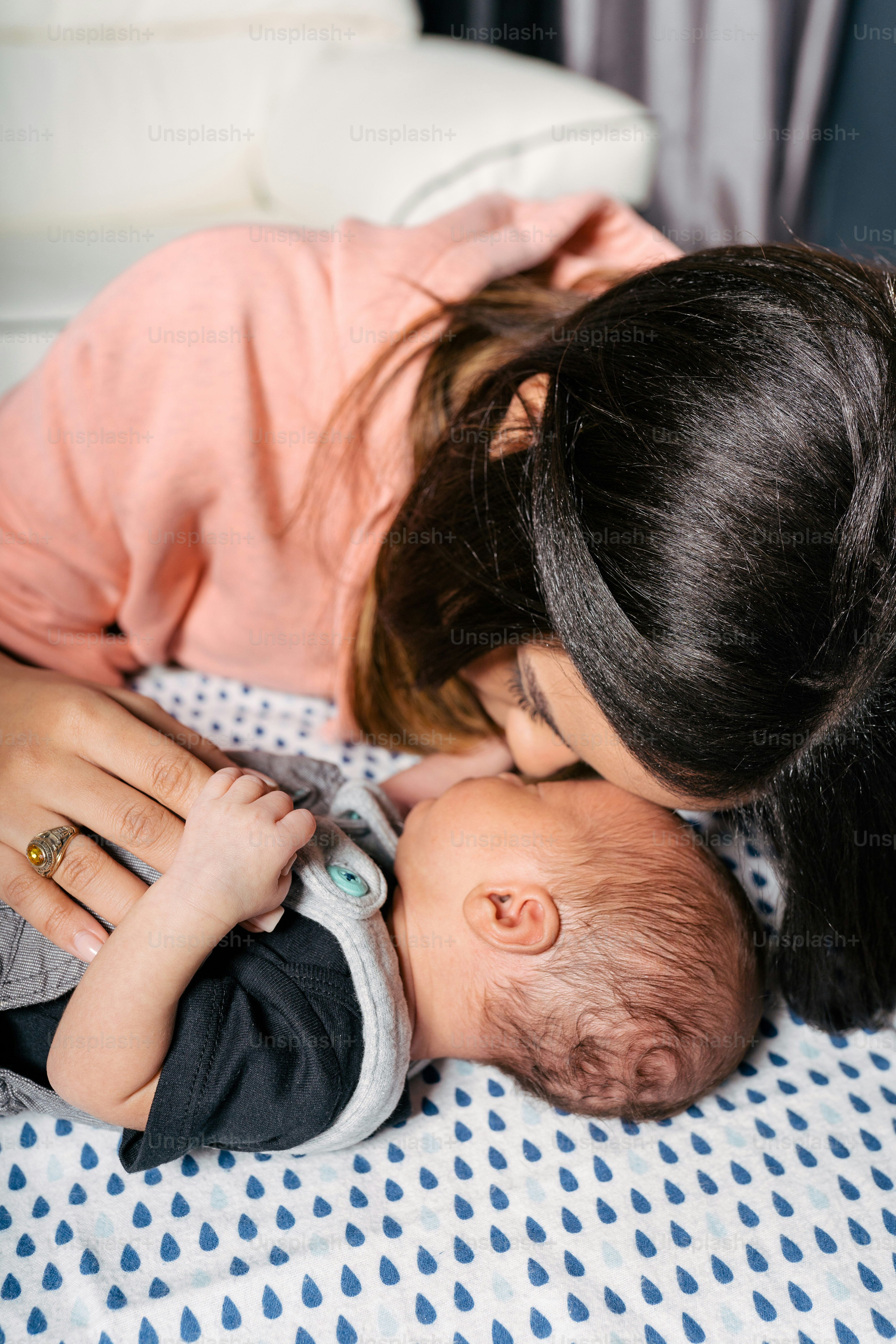 Une femme embrasse un bébé sur le lit